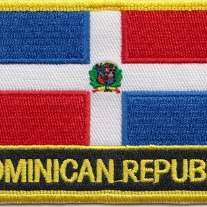 Puede incluir: Parche bordado con la bandera de la República Dominicana. La bandera es azul, blanca y roja con el escudo de armas del país en el centro. El parche tiene un borde amarillo y las palabras "REPÚBLICA DOMINICANA" en letras amarillas sobre un fondo negro.