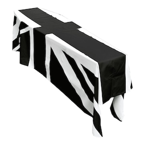 May include: A black and white table runner with a Union Jack design. The runner is made of fabric and has a satin finish.