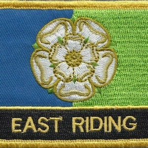 May include: A blue and green embroidered patch with a white rose and the text "EAST RIDING" in gold lettering.