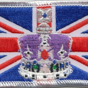 May include: A white embroidered patch with a red, white, and blue Union Jack flag design. A purple crown with silver accents is centered on the flag.