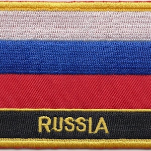 Könnte beinhalten: Ein weißer, blauer und roter gestickter Aufnäher mit schwarzem Hintergrund und dem Wort "RUSSIA" in goldenen Buchstaben.