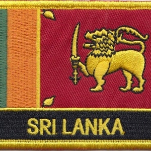 May include: A yellow embroidered patch with the Sri Lankan flag. The flag features a green, orange, and red background with a yellow lion holding a sword. The text "SRI LANKA" is embroidered in yellow on a black background.