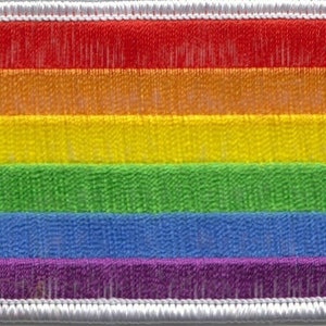 Op de afbeelding: Een stoffen patch met zes horizontale strepen in regenboogkleuren. De strepen zijn rood, oranje, geel, groen, blauw en paars.