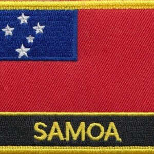 Puede incluir: Un parche bordado rojo y azul con cinco estrellas blancas y la palabra "SAMOA" en letras amarillas sobre fondo negro. El parche está rodeado por un borde amarillo.