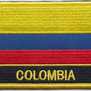Könnte beinhalten: Ein gestickter Aufnäher mit den Farben der kolumbianischen Flagge, gelb, blau, rot und schwarz, mit dem Wort "COLOMBIA" in gelben Buchstaben.