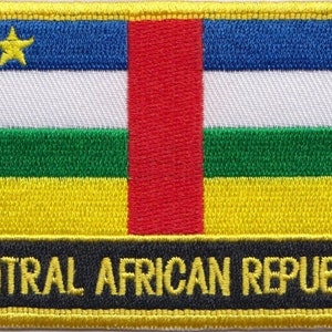 May include: An embroidered patch depicting the flag of the Central African Republic. The flag is a horizontal tricolour of blue, white, and green with a red vertical stripe in the centre. A yellow star is in the blue top left corner. The words "CENTRAL AFRICAN REPUBLIC" are printed in yellow on a black background below the flag.