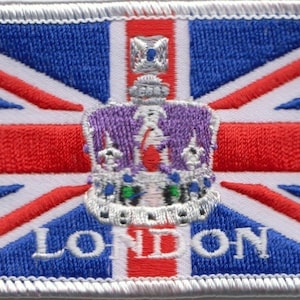 Könnte beinhalten: Ein weißer Patch mit einem rot-weiß-blauen Union-Jack-Flaggenmuster. Eine Krone befindet sich mittig auf der Flagge, und das Wort "LONDON" ist in Weiß unter der Krone aufgedruckt.