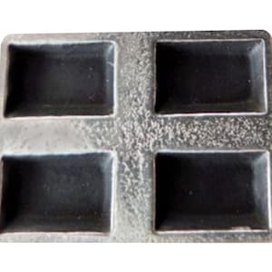 May include: A grey metal mould with four rectangular cavities. The mould is designed for making soap or other small items.
