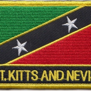Könnte beinhalten: Ein gelber gestickter Aufnäher mit einer grün-schwarz-roten Flagge mit zwei weißen Sternen. Der Text "ST. KITTS AND NEVIS" ist in Gelb auf schwarzem Hintergrund gestickt.