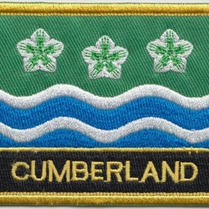 May include: An embroidered patch featuring three white flowers, blue and white waves, and the word "CUMBERLAND" in gold lettering on a black background.