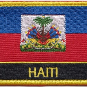 May include: An embroidered patch depicting the flag of Haiti. The flag is blue, red and black with a coat of arms in the centre. The text "HAITI" is embroidered in yellow on a black background.