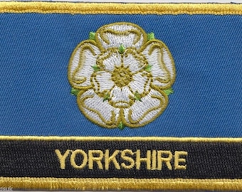 May include: A blue and gold embroidered patch with a white rose and the word "YORKSHIRE" in gold lettering.