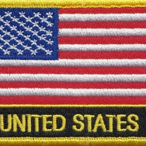 Puede incluir: Un parche bordado amarillo con una bandera estadounidense roja, blanca y azul y el texto "UNITED STATES" en letras amarillas sobre un fondo negro.