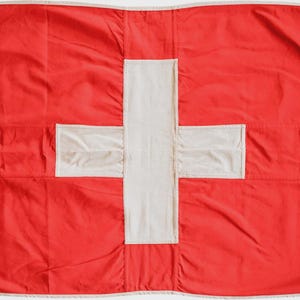 以下が含まれることがあります： スイスを象徴する、中央に白い十字がある赤い旗。旗には白い縁取りと吊り下げ用のハトメが付いています。素材は軽量です。