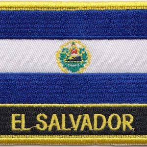Könnte beinhalten: Ein gestickter Aufnäher mit der Flagge von El Salvador. Die Flagge ist blau, weiß und blau mit dem Staatswappen in der Mitte. Der Aufnäher hat einen schwarzen Rand mit der Aufschrift "EL SALVADOR" in gelben Buchstaben.