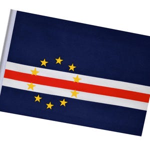 Könnte beinhalten: Kleine Flagge von Kap Verde, mit einem dunkelblauen Hintergrund, einem weißen und roten Streifen und einem Kreis aus zehn gelben Sternen. Die Flagge befindet sich auf einer weißen Stange.