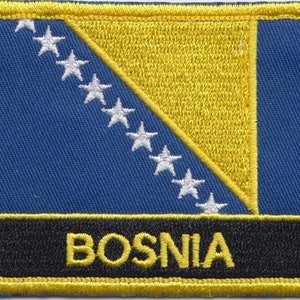 May include: A yellow embroidered patch with the flag of Bosnia and Herzegovina. The flag features a blue field with a yellow triangle containing eight white stars. The text "BOSNIA" is embroidered in yellow on a black background.
