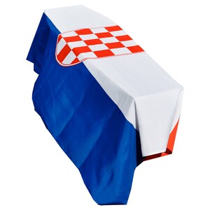 May include: A white, blue, and red tablecloth with the Croatian flag design. The tablecloth is draped over a table.