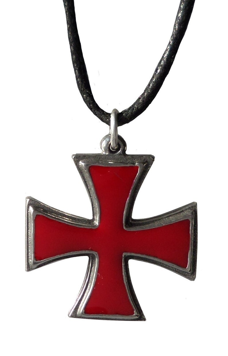May include: A silver pendant necklace with a red enamel Maltese cross. The necklace has a black cord.
