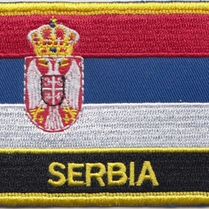 May include: Embroidered patch featuring the flag of Serbia. The flag is red, blue, and white with the coat of arms of Serbia in the centre. The patch has a black border with the word "SERBIA" in yellow lettering.