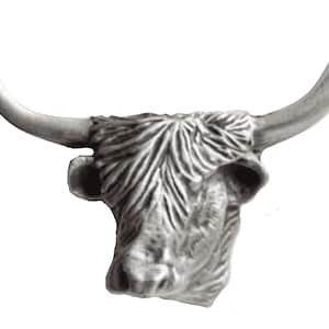 Puede incluir: Una escultura de cabeza de vaca Highland de plata con cuernos largos y fluidos y una cara detallada.