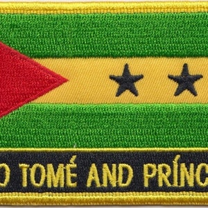 Op de afbeelding: Geborduurde patch met de vlag van Sao Tomé en Principe. De vlag is groen, geel en rood met twee zwarte sterren. De tekst "SAO TOME AND PRINCIPE" staat in zwarte letters op een zwarte achtergrond.