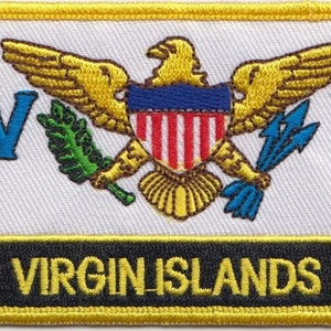 Op de afbeelding: Een geborduurde patch in geel, wit en blauw met de woorden "VIRGIN ISLANDS" in gele letters op een zwarte achtergrond. De patch toont een gouden adelaar met een schild op zijn borst, een groene krans en twee blauwe speren.