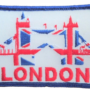 Könnte beinhalten: Ein weißer gestickter Aufnäher mit einem roten und blauen Bild der Tower Bridge und dem Wort "LONDON" in rot.