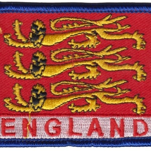 Könnte beinhalten: Ein roter und weißer gestickter Aufnäher mit drei goldenen Löwen und dem Wort "ENGLAND" in weißen Buchstaben.