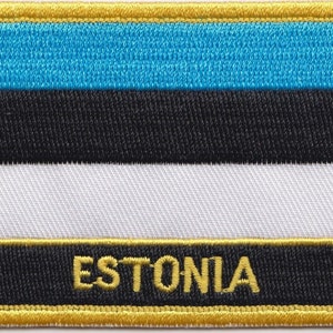 Könnte beinhalten: Ein blauer, schwarzer und weißer gestickter Aufnäher mit goldener Umrandung und dem Wort "ESTONIA" in goldenen Buchstaben.