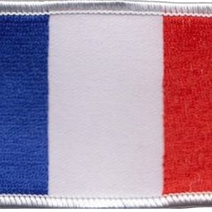 May include: A blue, white and red fabric patch with a stitched border. The patch features the colours of the French flag.