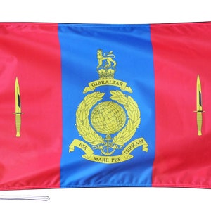 May include: A rectangular flag with a red background and a central blue stripe. The flag displays a gold emblem with text and two gold knives. The text reads "GIBRALTAR" and "PER MARE PER TERRAM".