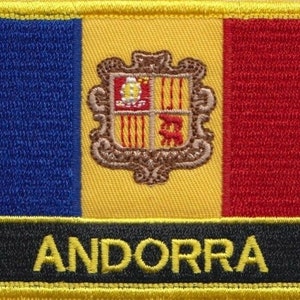 Pode incluir: Um remendo bordado com o brasão de armas de Andorra, com um design amarelo, azul e vermelho. A palavra "ANDORRA" está bordada em amarelo sobre um fundo preto.