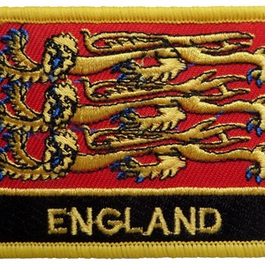 May include: An embroidered patch with a red background and gold lions. The patch has a black border with the word "ENGLAND" in gold lettering.