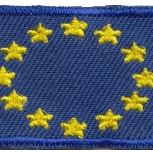 Pode incluir: Um remendo de tecido azul com um círculo de 12 estrelas amarelas. O remendo é orlado com fio azul.