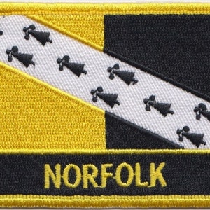 May include: A yellow and black embroidered patch with a white diagonal stripe and black bells. The patch has the word "NORFOLK" in yellow lettering on a black background.