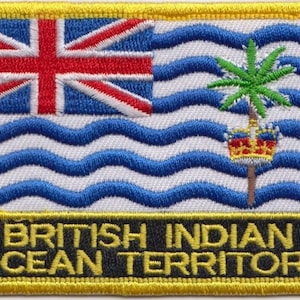 May include: A yellow embroidered patch with the flag of the British Indian Ocean Territory. The flag features a blue Union Jack in the upper left corner and a white background with blue wavy lines representing the ocean. A green palm tree with a red, white, and blue crown on top is centered on the flag. The text "BRITISH INDIAN OCEAN TERRITORY" is written in yellow letters on a black background below the flag.