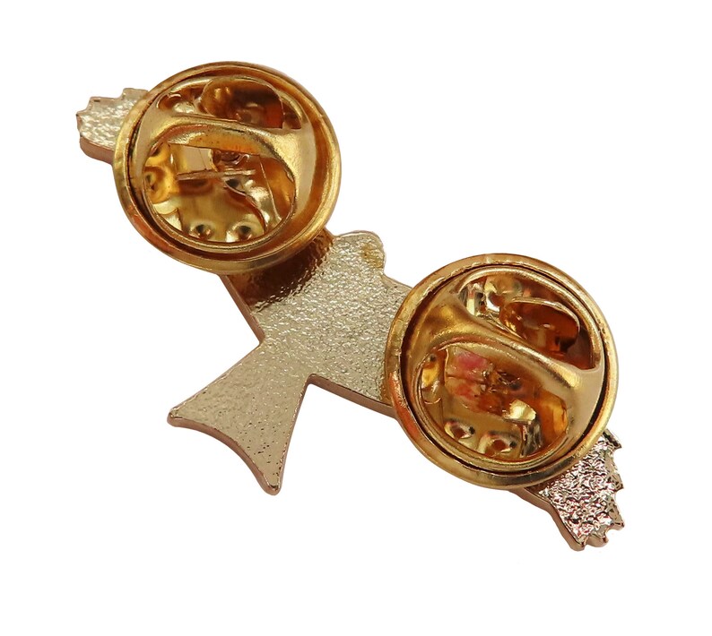 May include: Gold-tone metal pin with a stylized bird design. The back of the pin has two butterfly clasps.