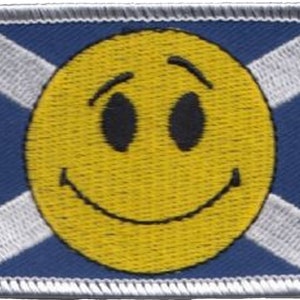 May include: A blue and white Scottish flag with a yellow smiley face in the centre.