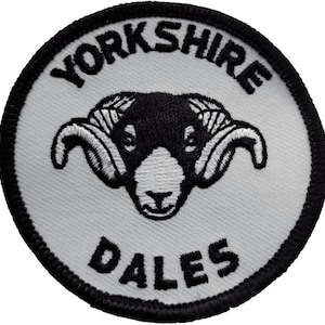 May include: White embroidered patch with black stitching. The patch is round and features a black and white ram's head with the text "YORKSHIRE DALES" around the edge.