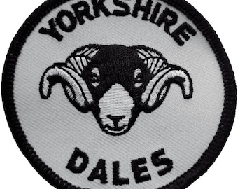 May include: White embroidered patch with black stitching. The patch is round and features a black and white ram's head with the text "YORKSHIRE DALES" around the edge.