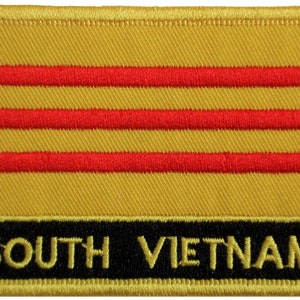 May include: A yellow embroidered patch with three red horizontal stripes and the text "SOUTH VIETNAM" in black.