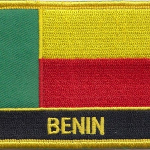 Könnte beinhalten: Ein gestickter Aufnäher mit den Farben der Flagge Benins: grün, gelb und rot. Das Wort "BENIN" ist in Gelb auf schwarzem Hintergrund gestickt.