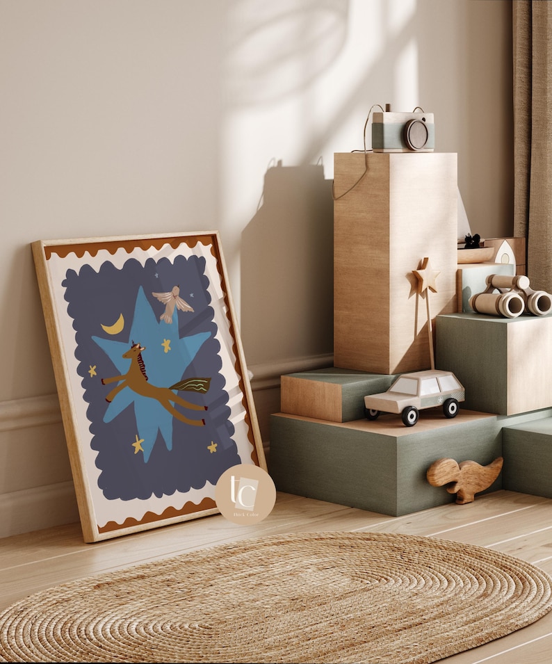 May include: A framed art print featuring a whimsical illustration of a brown horse leaping across a blue star, with a crescent moon and bird. The artwork is in a wooden frame. A toy camera, car, and dinosaur are on display.