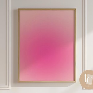 May include: A framed abstract art print with a pink to white gradient. The frame is gold.