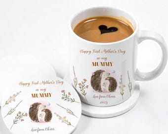 May include: White ceramic mug with a brown hedgehog design and the text "Happy First Mother's Day as my MUMMY Love from Oliver 2025". The mug is sitting on a white ceramic coaster with the same design.