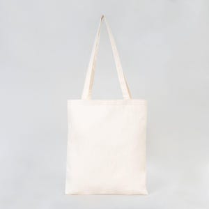 May include: A plain white canvas tote bag with two long handles.