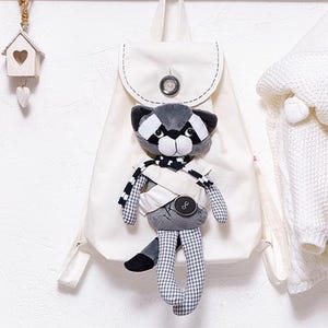 Baby Doll Träger Rucksack. Waschbär Stofftier Tragetasche