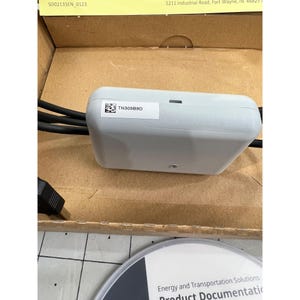 May include: A light gray electronic device with the text "TN309B9D" on a white label. The device has black cables and a USB connector. The device is in a cardboard box with a product documentation disc.