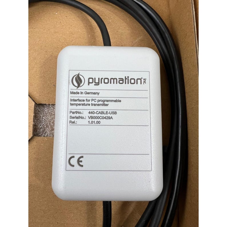 May include: A white Pyromation interface for PC programmable temperature transmitter with black cables. The device has the text "Made in Germany" and "CE" printed on it. Part number is 440-CABLE-USB.